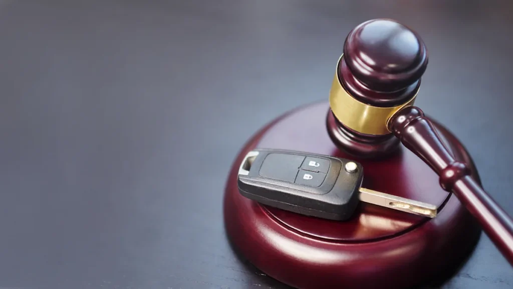 Une clé de voiture posée sur un marteau de la justice
