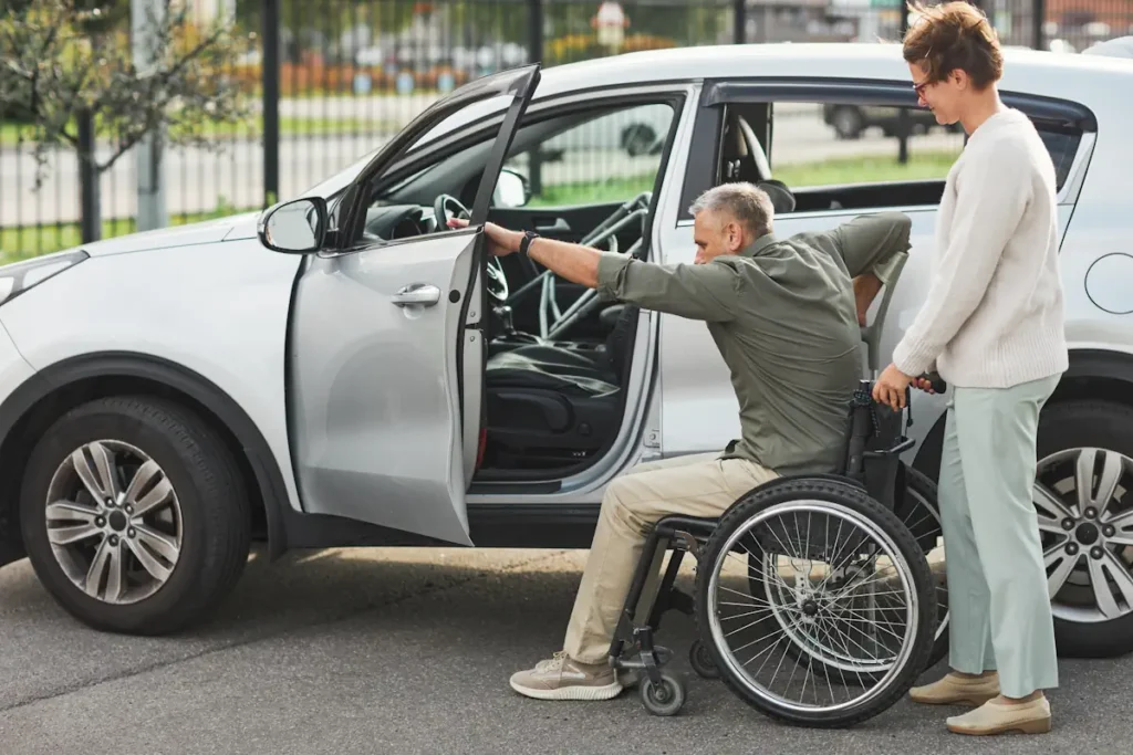 un homme à mobilité réduite qui essaie de monter dans une voiture