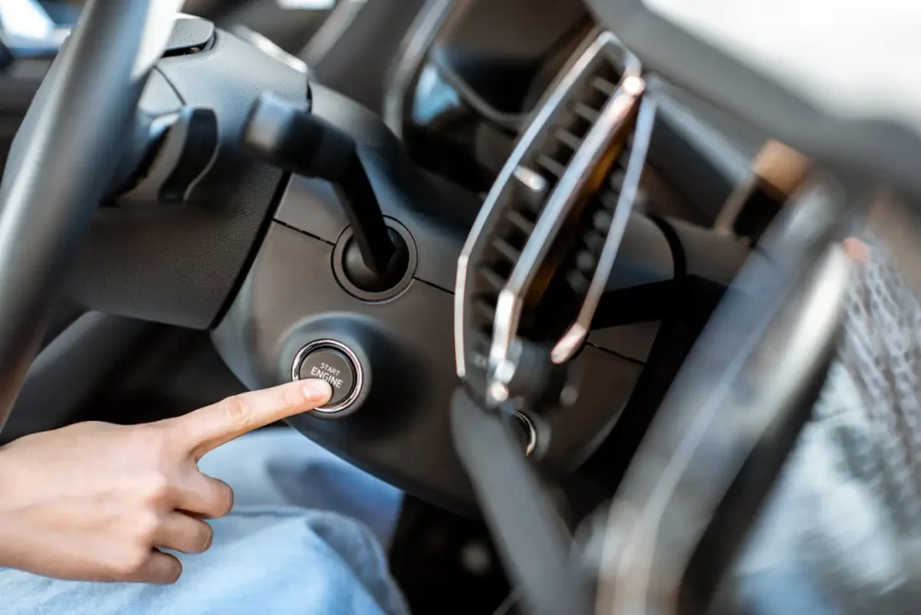 Une personne qui appuie sur le bouton On d'une voiture
