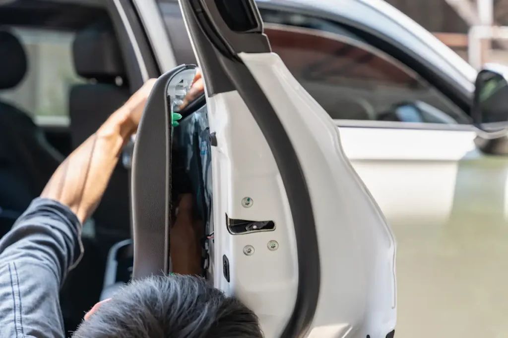 Un homme qui ouvre la porte d'une voiture pour voir les mécanismes intérieurs