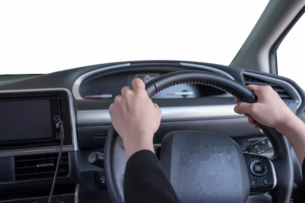 Une personne avec les mains sur le volant