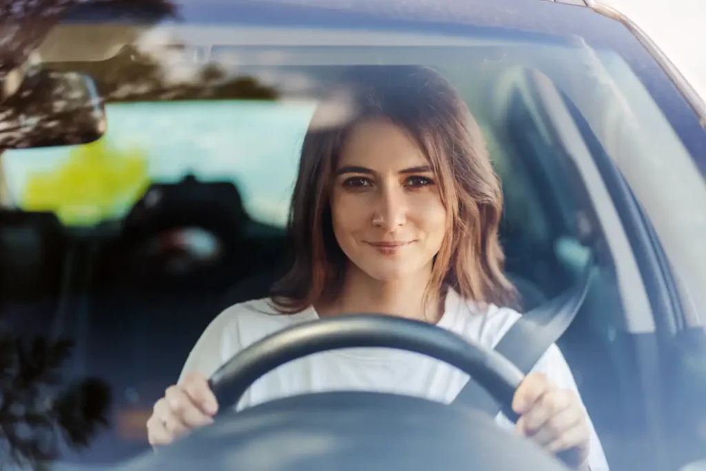 Une femme qui roule en voiture en tenant son volant