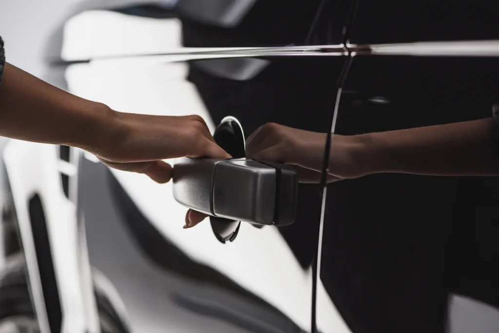 Une personne qui essaie d'ouvrir la porte d'une voiture noire