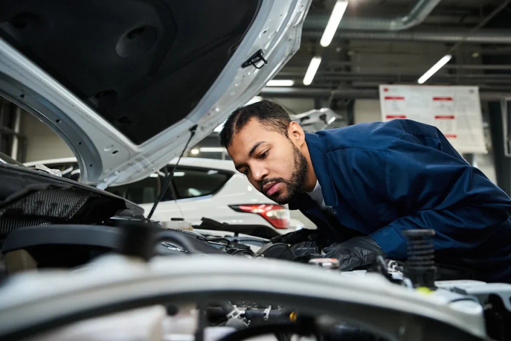 Un professionnel qui regarde sous le capot d'une voiture