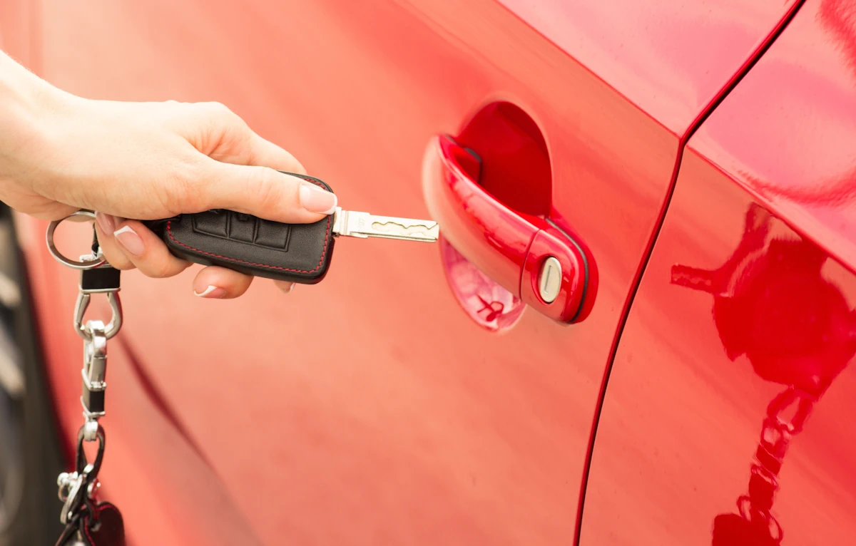 Une personne qui tient une clé de voiture électrique