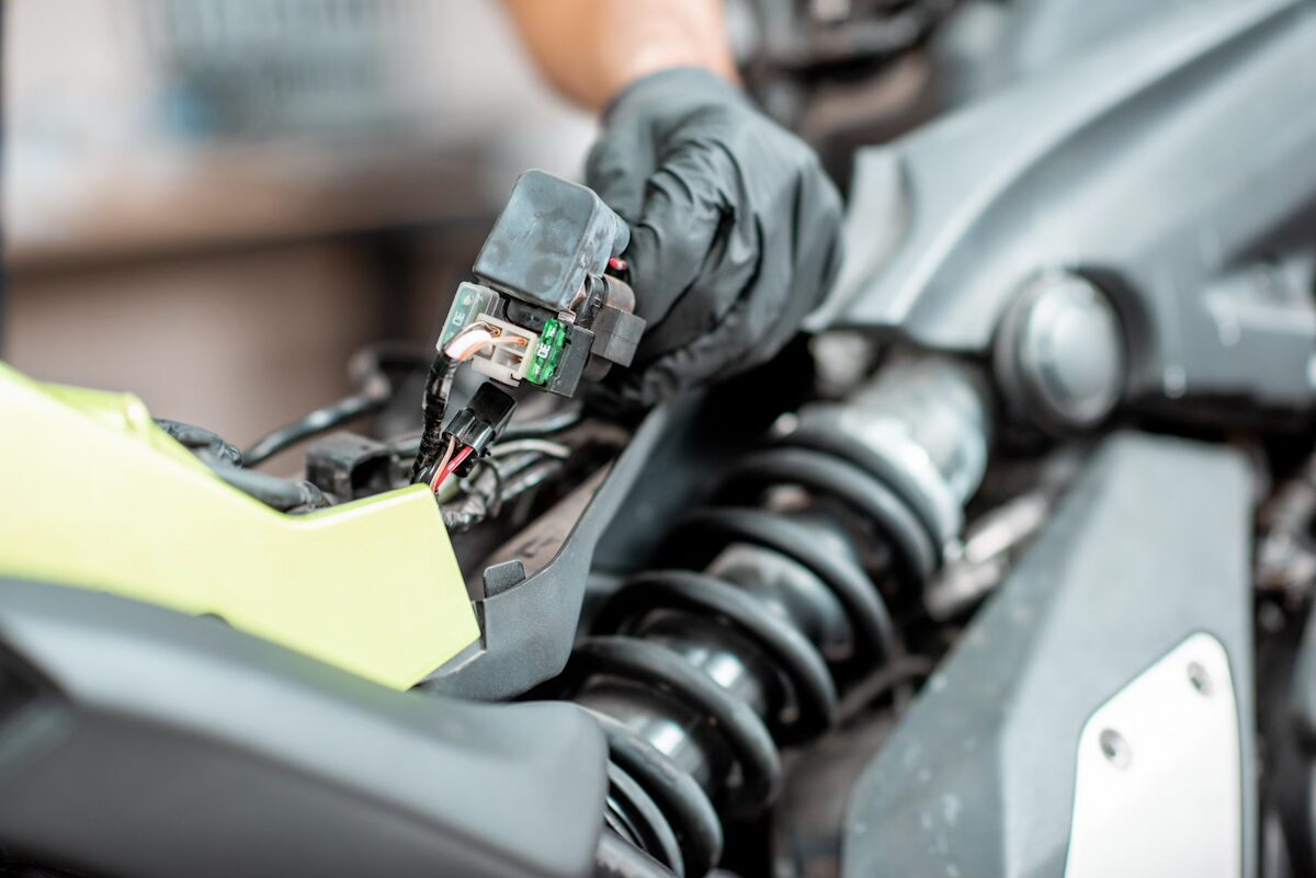 Une main gantée qui regarde des fils électriques