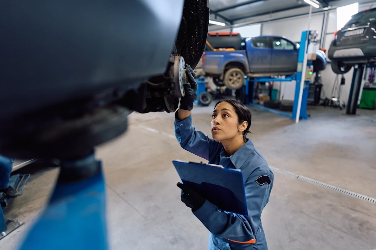 Une femme qui effectue un contrôle technique sur une voiture